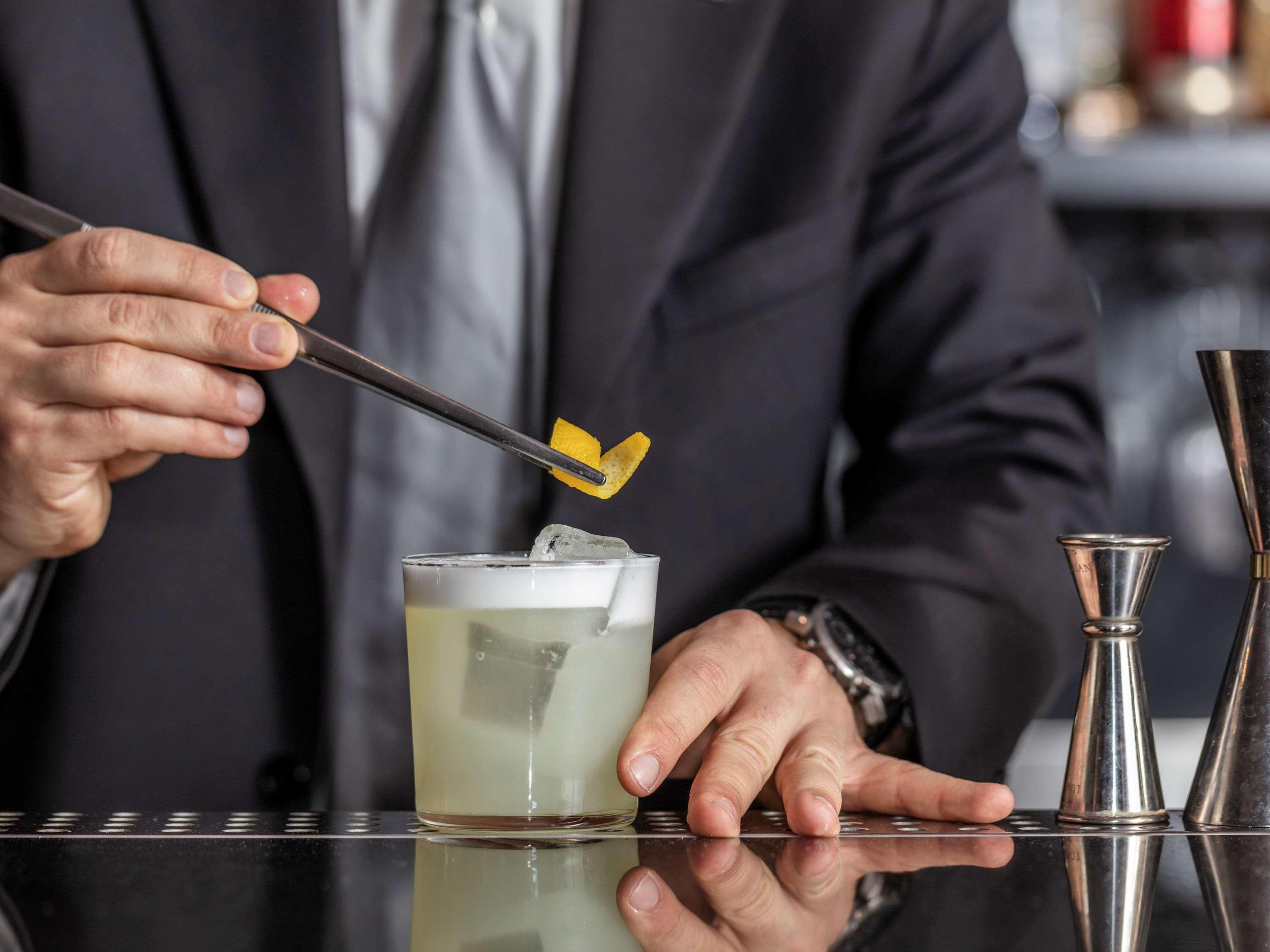 Hotel La Griffe Roma Esterno foto A bartender adding a lemon twist to a cocktail